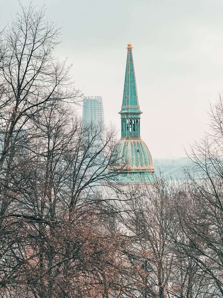 Bratislava at Christmas during the day, adorned with festive decorations, and the majestic Bratislava Castle overlooking the city under a clear winter sky.