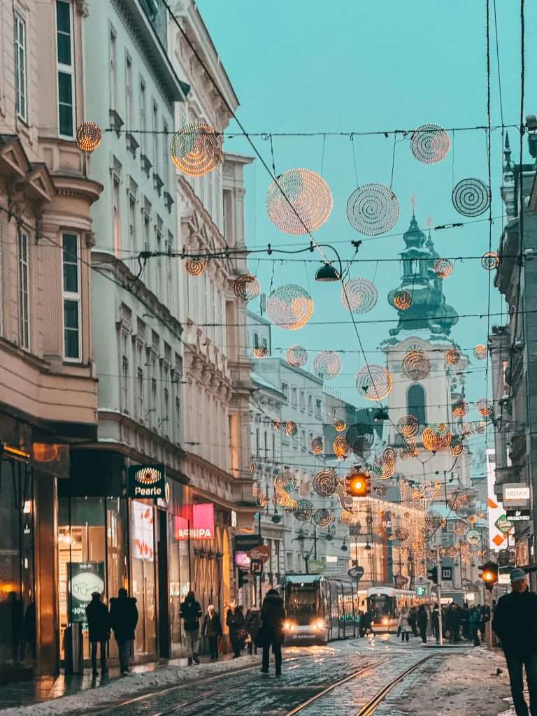 Christmas streets and sparkling markets in Linz, adorned with festive lights, colorful decorations, and bustling holiday stalls creating a magical holiday atmosphere.