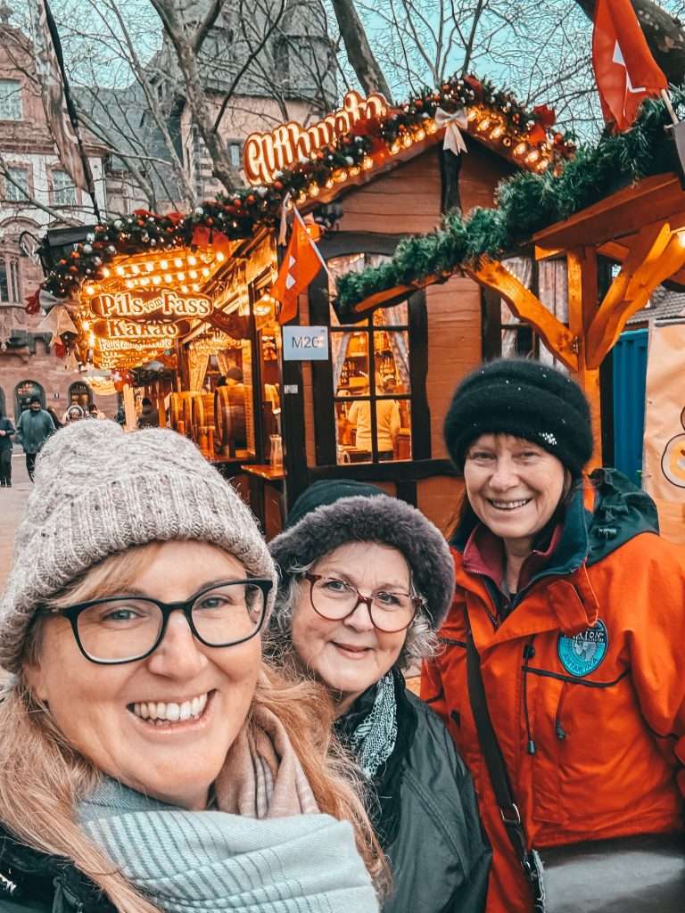 Frankfurt Christmas Markets bustling with holiday cheer, featuring traditional wooden stalls, festive lights, and seasonal decorations, with the historic architecture of the city in the background Seeds of Travel