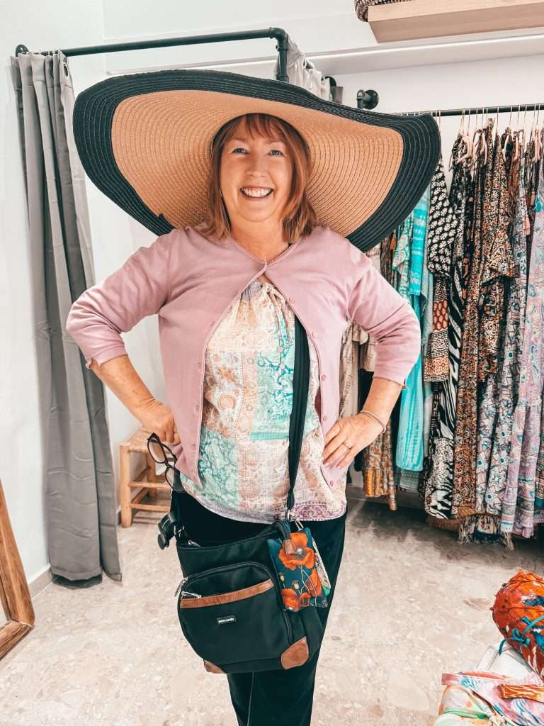 Lady trying on hat shopping in Naoussa Greece