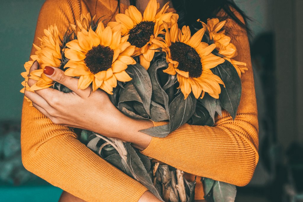 lady holding sunflowers seeds of travel